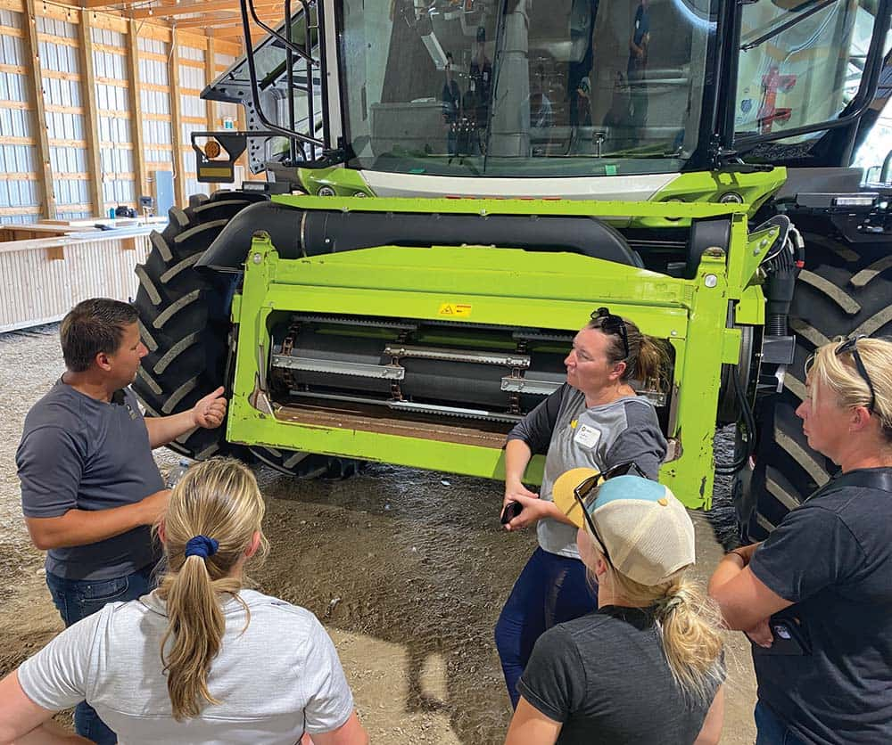 Shawn Senko and Candice Harris are agronomists that are explaining to a group of people how to clean a combine in an optimized way.