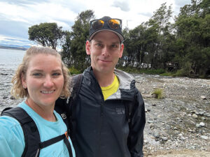 The Hazletts outdoors taking a selfie at a stone beach.