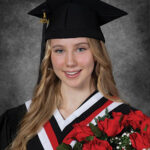 Laura Delichte in a graduation gown and 2024 graduation cap, holds a bouquet of roses.