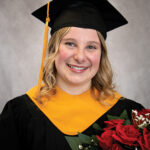 Madisyn Robertson in a graduation gown and graduation cap, holds a bouquet of roses.