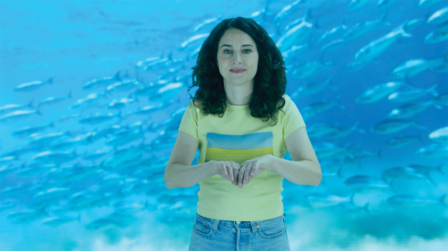 Hello Canadian Canola girl swimming with a group of fish underwater