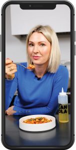 A mockup of a cellphone with Abbey eating a dish of food made with canola oil.